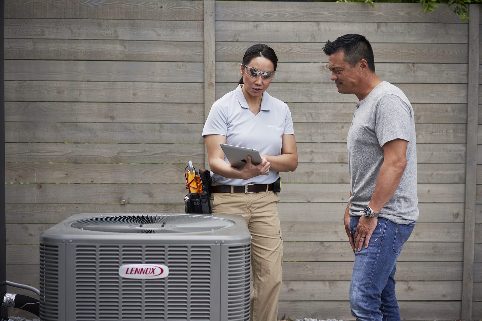 Deals Heating & Air technician reviewing HVAC system diagnostics with a homeowner during a Lennox air conditioner service visit.